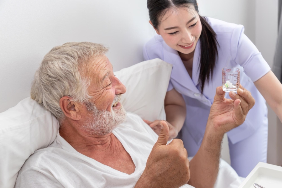 happy-nurse-give-pills-assist-encourage-elderly-senior-man-eat-medicine-after-breakfast-bed-bedroom-nursing-home
