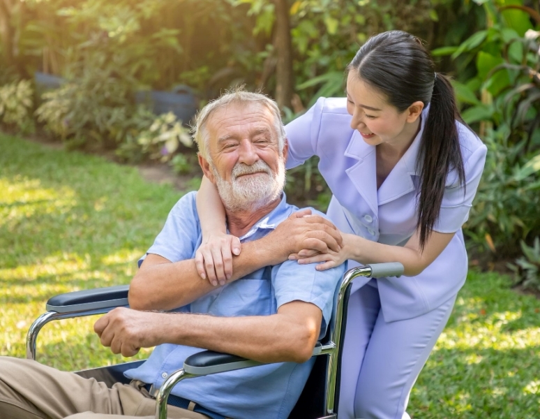 happy-nurse-holding-elderly-man-hand-wheelchair-garden-nursing-home