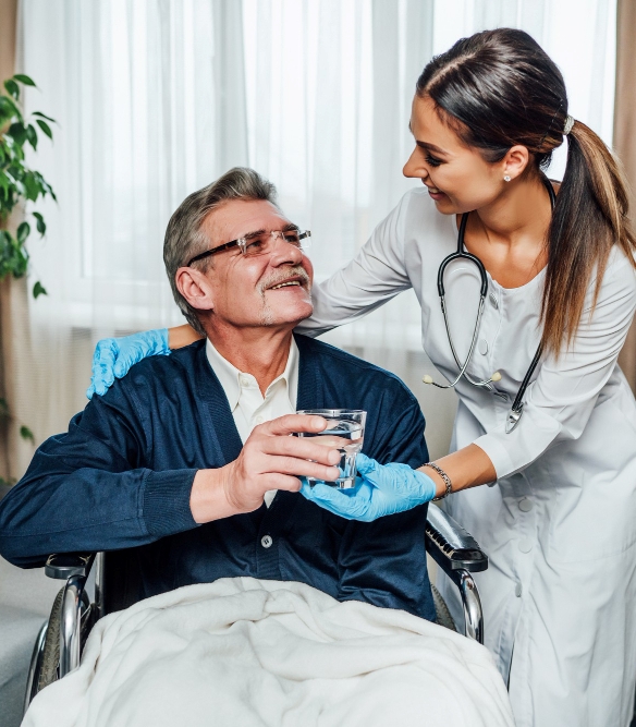 older-man-wheelchair-smiles-nurse-assistant-she-hands-him-glass-water