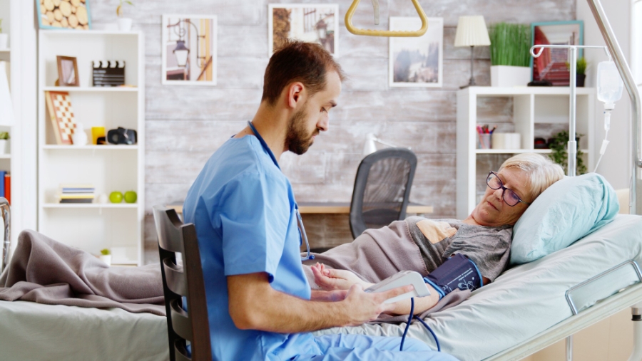 retirement-home-male-nurse-checks-old-sick-lady-blood-pressure-nursing-home-worker