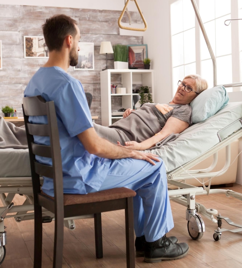 young-doctor-sitting-sick-old-woman-nursing-home